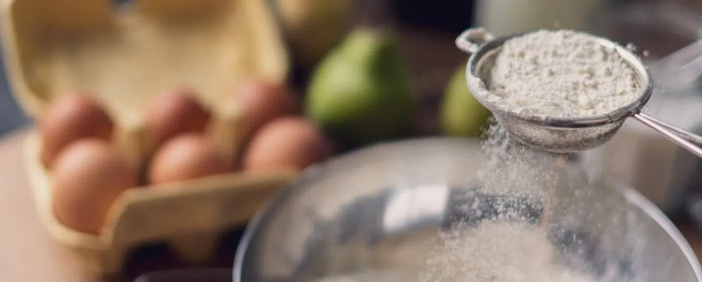 decorative Sifting flour with eggs in the background