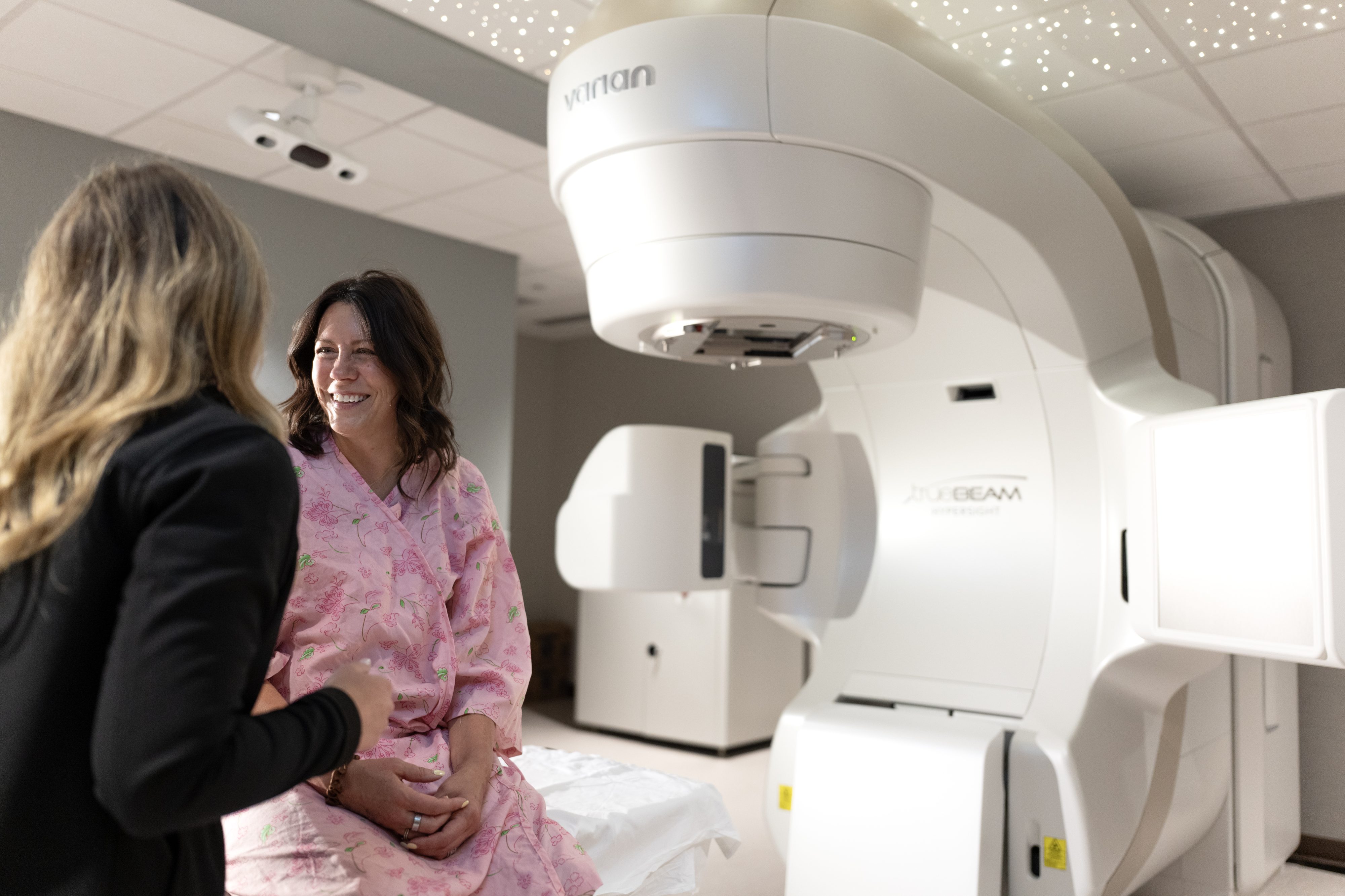 Patient and care team member talking beside a radiation treatment machine at Rocky Mountain Cancer Centers