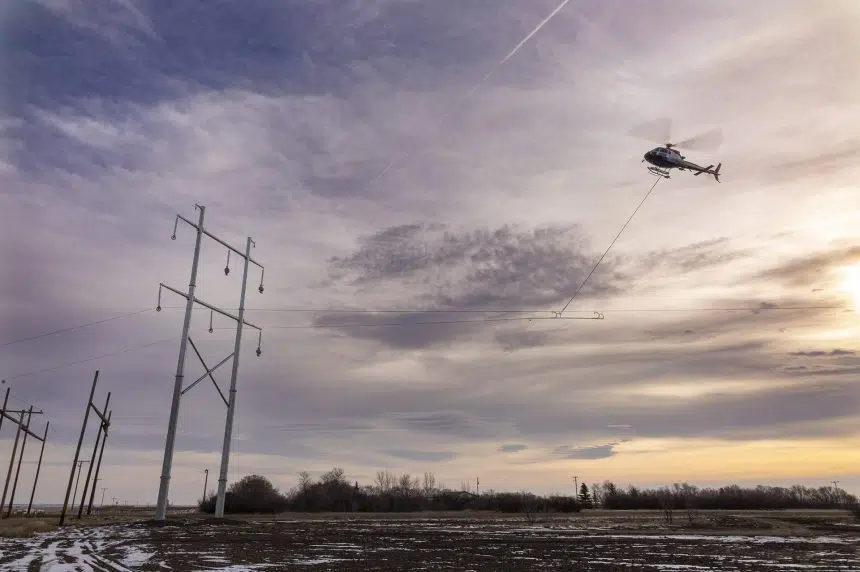 Chopper installing power lines over Highway 1 near Rush Lake