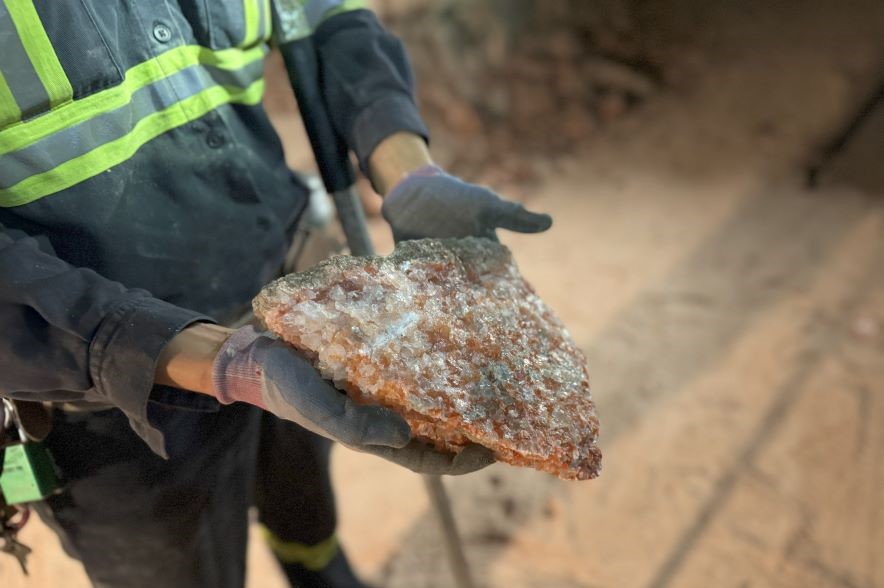 A worker holds a chunk of potash at a mine in Allan, Sask.
