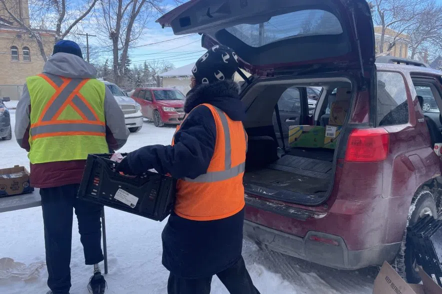 Volunteers help unload food from vehicles.