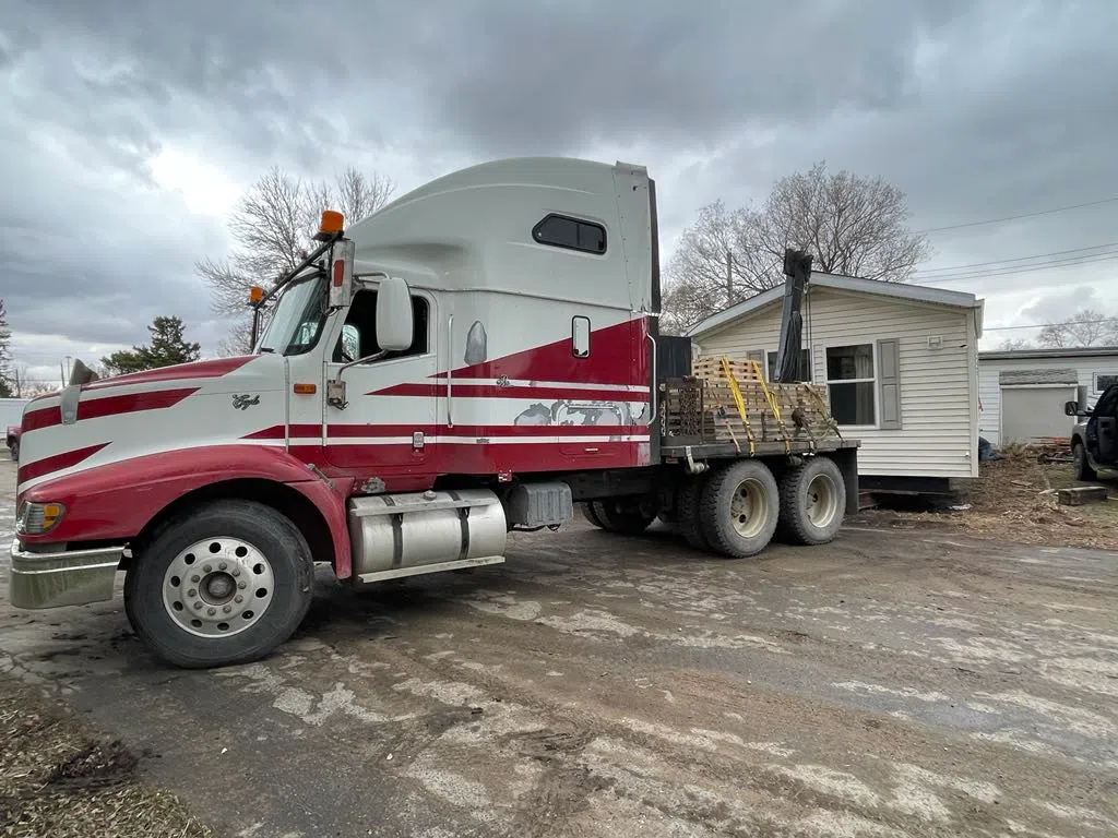 A mobile home is moved by a semi.