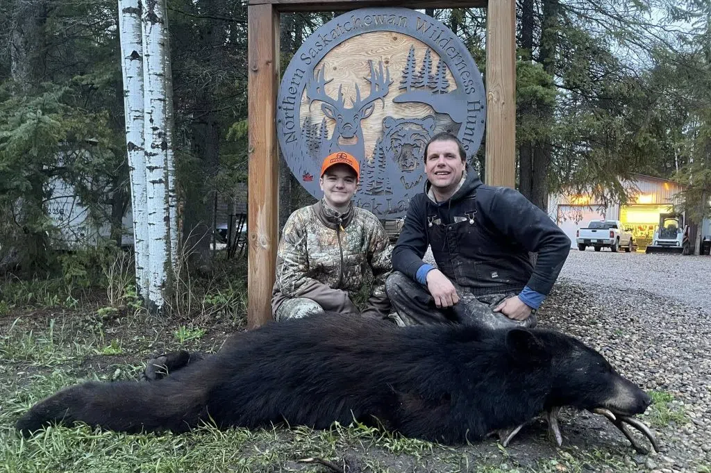 Michael (right) with a hunter named Clayton who killed his first black bear at his outfitter. (Northern Saskatchewan Wilderness Hunts Inc./Facebook)