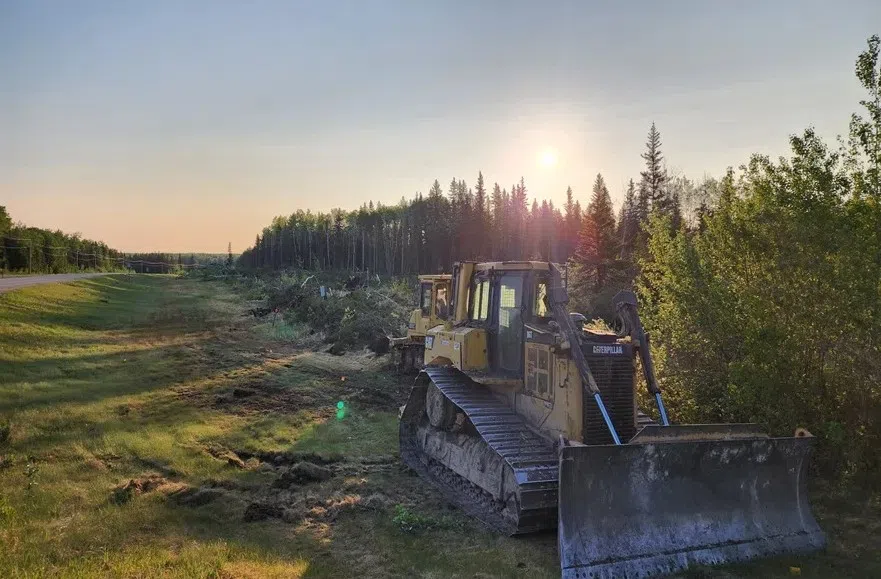 Two Bulldozers sit in the ditch along highway 120 to construct the Candle Lake firebreak (Roman Hayter/980 CJME)