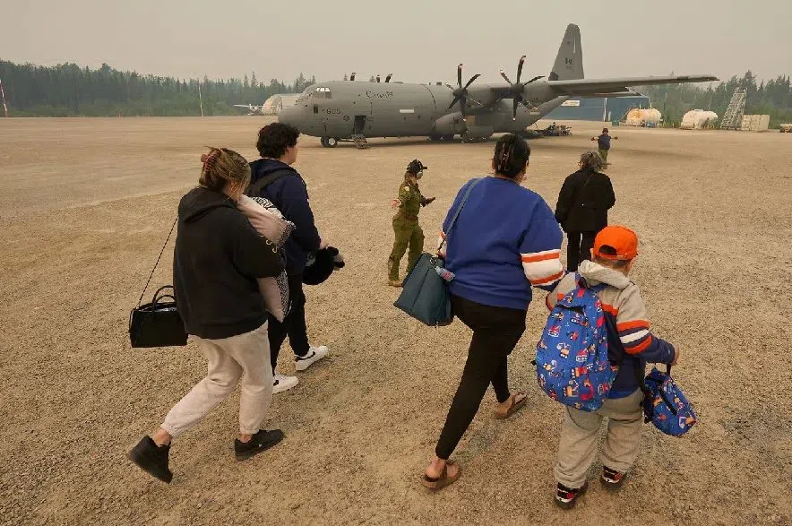 Members of the Royal Canadian Air Force help the Munroe family board a C-130 Hercules aircraft in Norway House, Man., Tuesday, June 3, 2025, at the Norway House Airport as crews continue to fight wildfires in northern Manitoba. THE CANADIAN PRESS/David Lipnowski