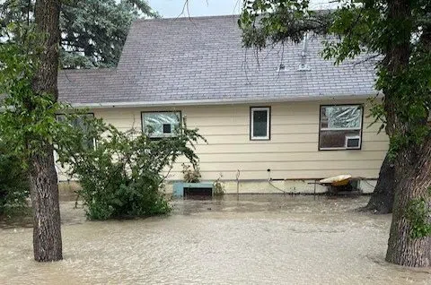 Water covers lawn, reaching up several inches on side of home