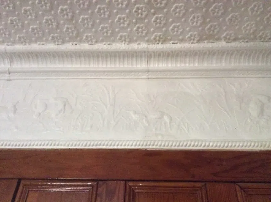 White crown molding with raised relief of deer and grassland scene