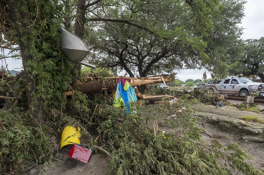 Bent canoe and debris stuck high in a tree.