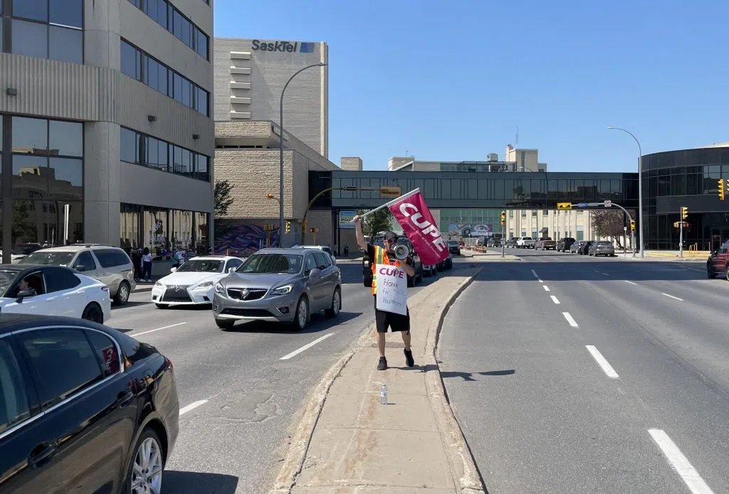 One person used a megaphone to chant “honk for healthcare” and a “fair deal with living wages” on Saskatchewan Drive’s median between the casino and Delta. (Marija Robinson/980 CJME)