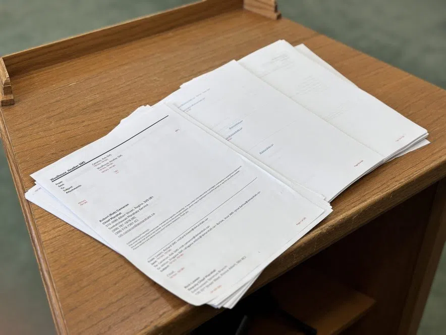 A stack of Saskatchewan government documents with most of the content blacked out in response to a misconduct inquiry.