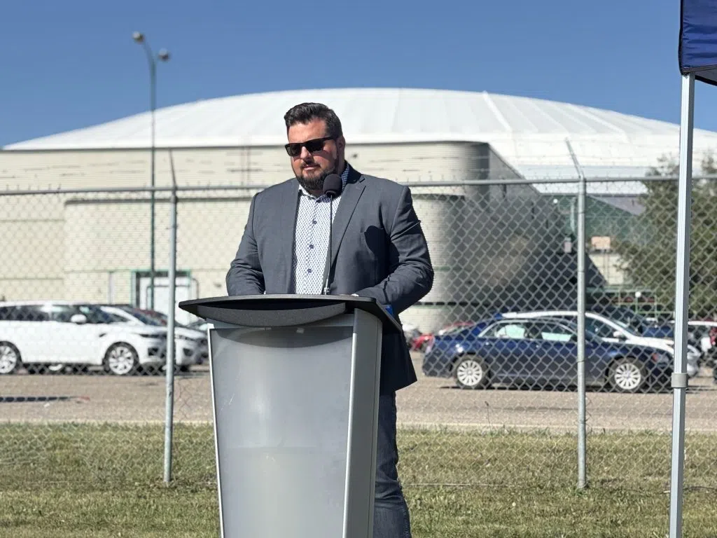 Saskatchewan Government Relations Minister Eric Schmalz speaking at podium outdoors.