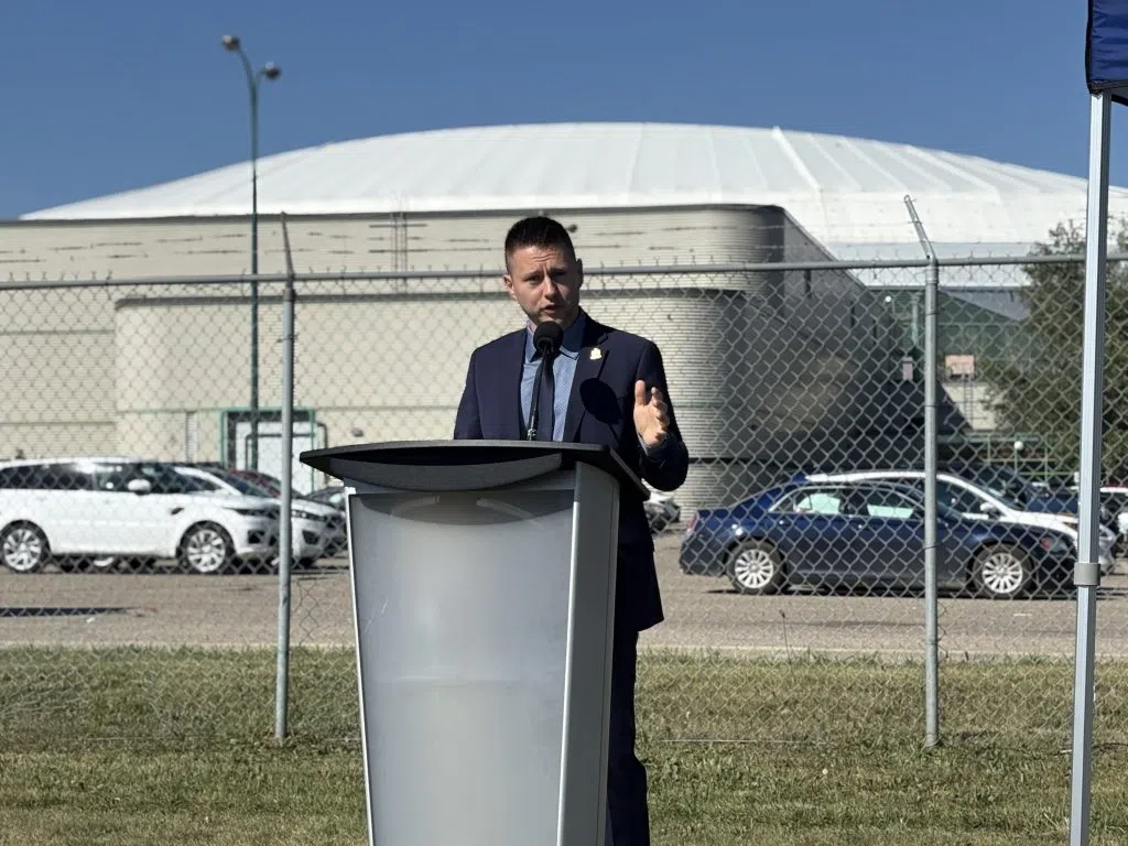 Regina Mayor Chad Bachynski speaks at podium in front of Sportplex.
