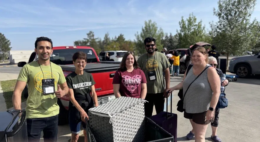 Chloe Baron, a first-year film production student, poses with family beside their vehicle after moving into University of Regina residence on move-in day.
