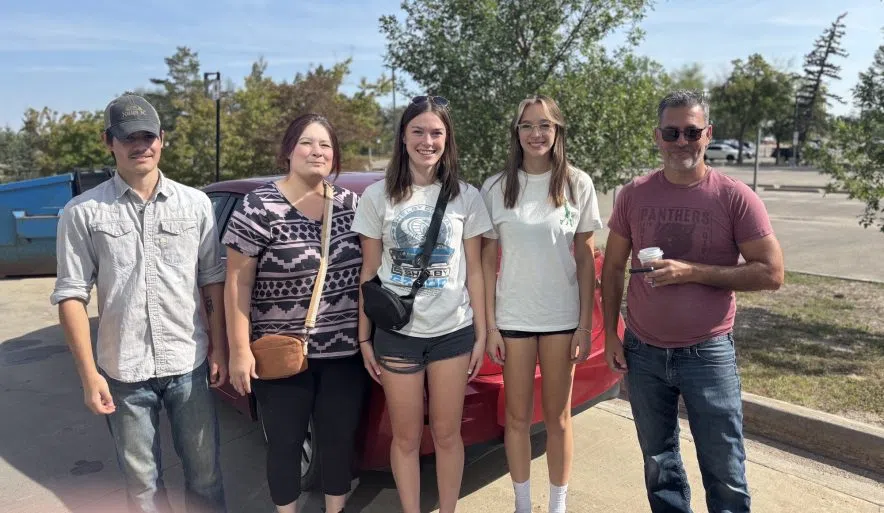 Devlny Mclung, a first year kinesiology student, stand witf family beside their vehicle afrer moving into University of Regina residence move-in day