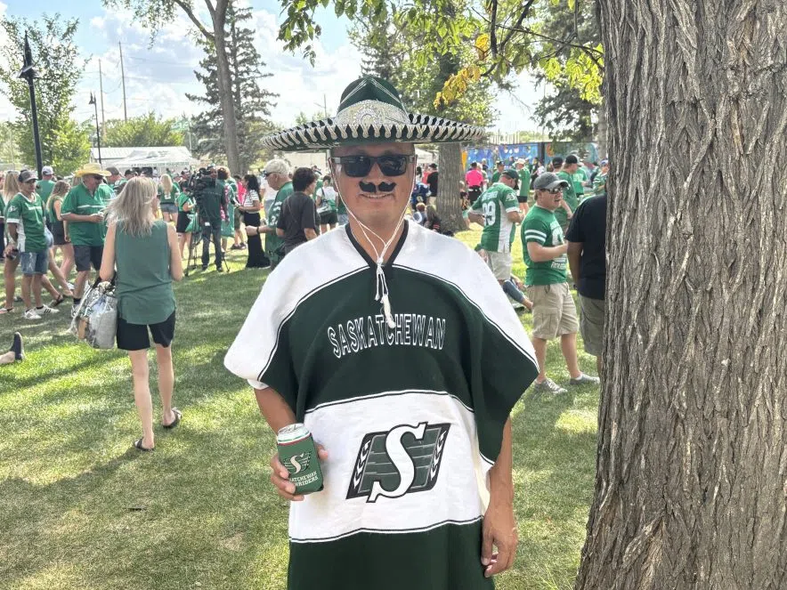 Rider fan Andy Cook wears a sombrero and poncho while holding a can of Pilsner at the tailgate.