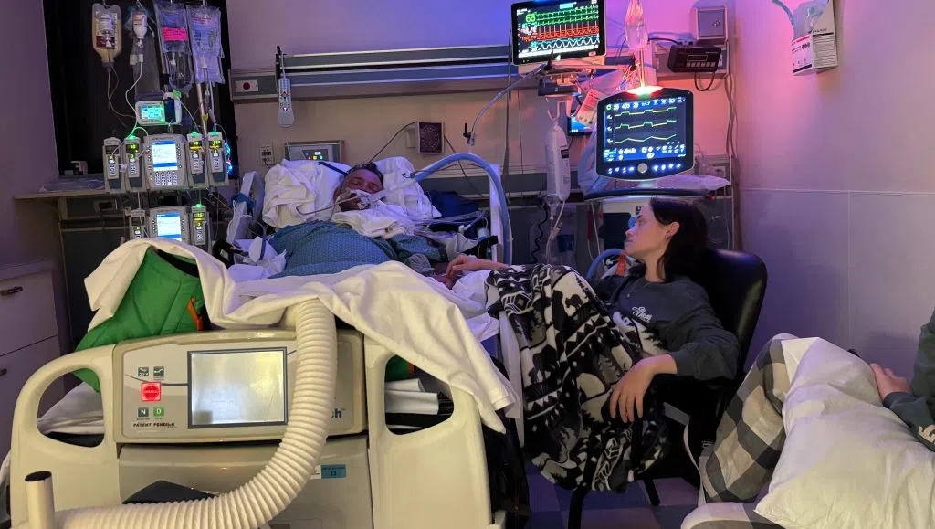 Man lays in an ICU bed in Texas.