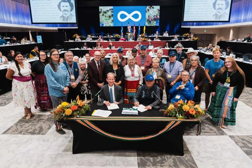 University of Regina and Métis Nation–Saskatchewan leaders sign a citizenship agreement in front of a group of Métis citizens at the MN–S assembly.