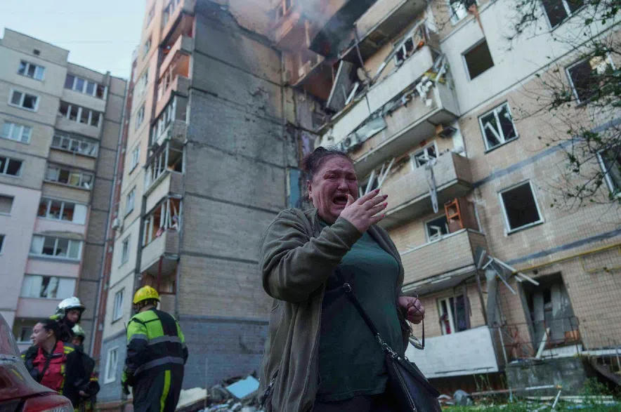 Woman and damaged buidling in Kyiv.