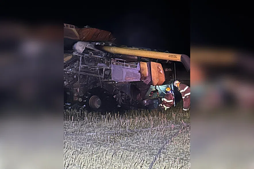 Firefighters help put out flames on a combine near Zenon Park.