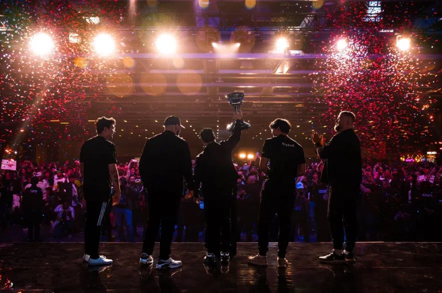 Shopify Rebellion celebrates its 2025 Halo World Championship win in Seattle as Regina gamer Mathew “Royal2” Fiorante raises the trophy under falling confetti.