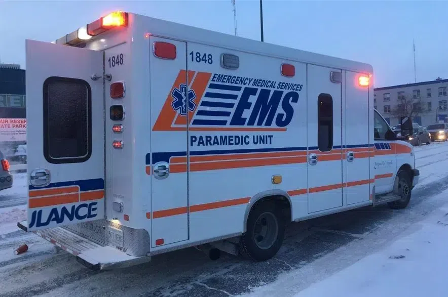 An ambulance with its rear doors open on a Regina street in the winter.