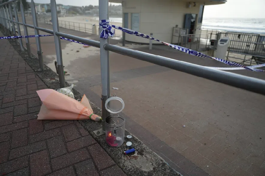 Candles and flowers are left in the early morning following a shooting Sunday at Sydney's Bondi Beach, Monday, Dec. 15, 2025.