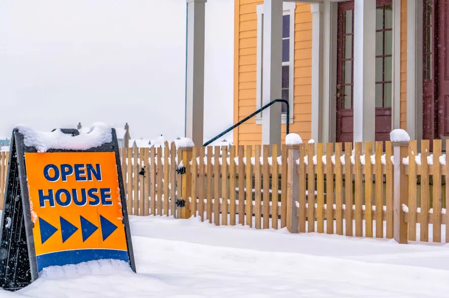 Open house sign in snowy yard.
