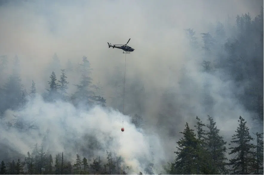 helicopter files water to wildfire