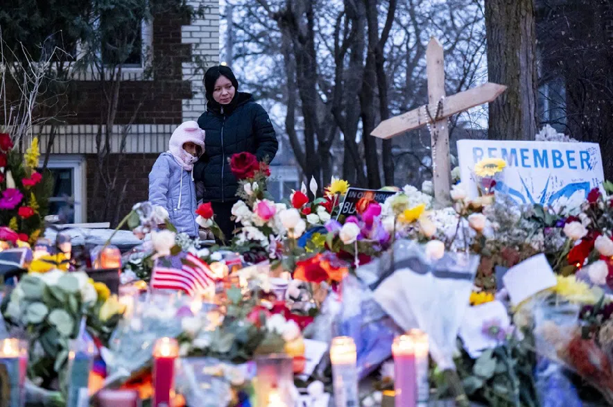 People pay their respects at a memorial honouring a woman who was fatally shot by an Immigration and Customs Enforcement officer the day before, near the site of the shooting in Minneapolis, Minn. on Thursday, January 8, 2026.