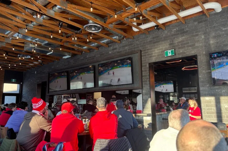 Fans watch the Olympic gold medal hockey game between Canada and the United States at Boston Pizza Acre 21 in Regina as the game heads into overtime.