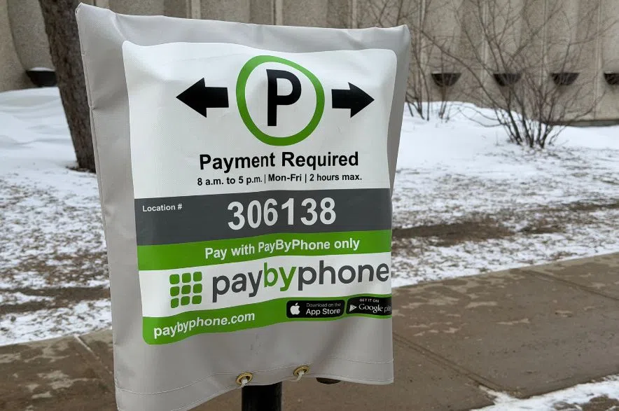 A parking meter has a sign advertising the new paybyphone method.