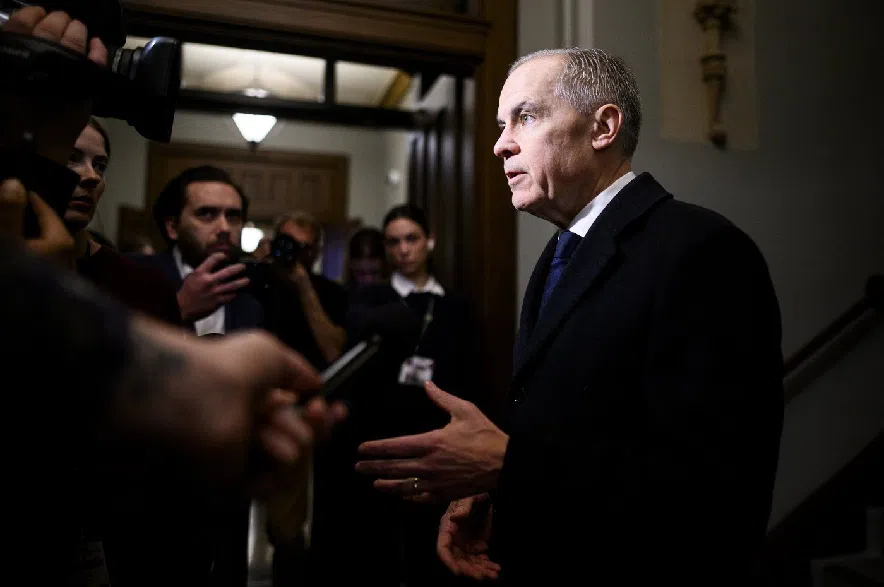 Prime Minister Mark Carney speaks to reporters ahead of a caucus meeting on Parliament Hill in Ottawa, on Wednesday, Feb. 11, 2026.