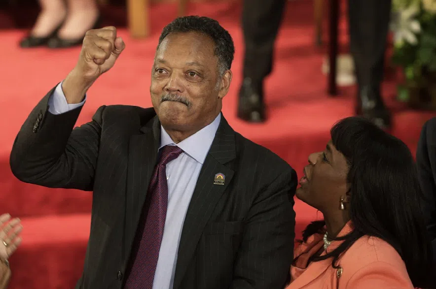 Rev. Jesse Jackson gestures to a friend in the balcony at the 16th Street Baptist Church in Birmingham, Ala., Sept. 15, 2013. The church held a ceremony honoring the memory of the four young girls who were killed by a bomb placed outside the church 50 years ago by members of the Ku Klux Klan. At right is U.S. Rep. Terri Sewell, D-Ala.