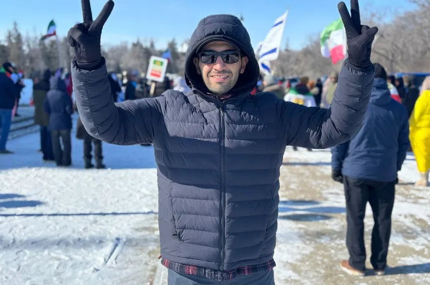 Nasire Zeba raises hands during Iranian Canadian rally in Regina.