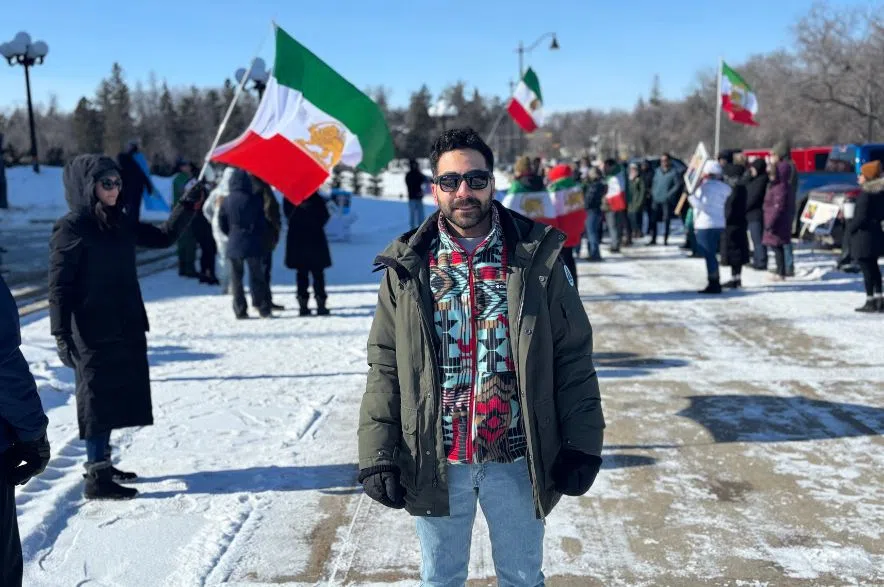 Dariush Davoodi foreground, Parastu Mohajer holds Lion and Sun flag behind him