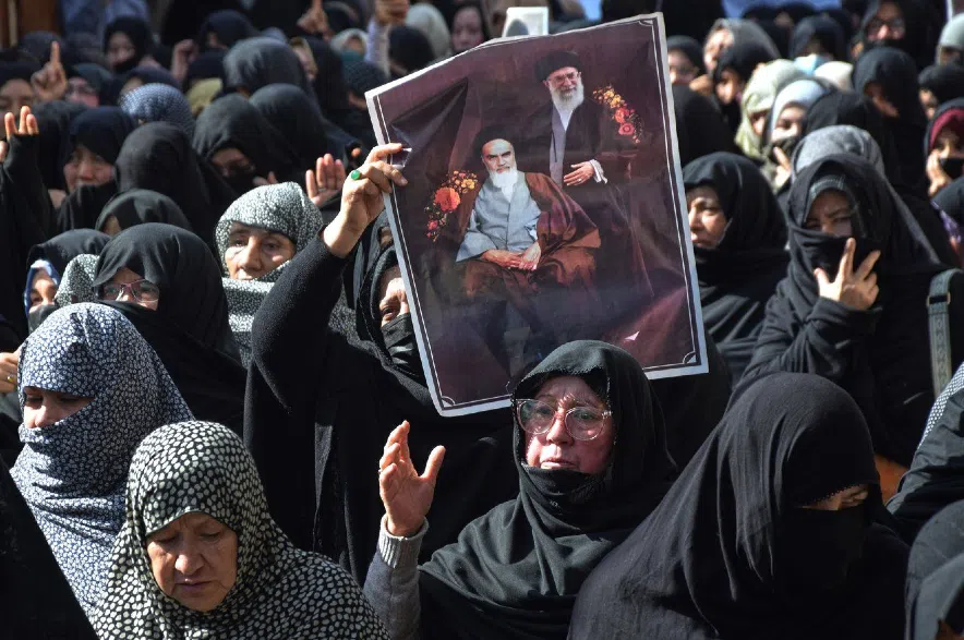 Shiite Muslims hold the portraits of Iranian leaders during a rally.