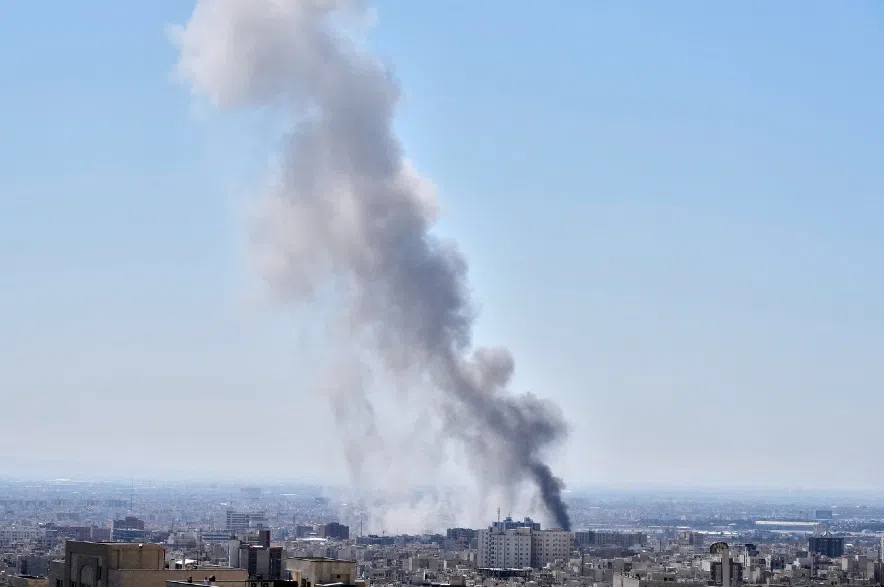 A plume of smoke rises after a strike in Tehran, Iran.