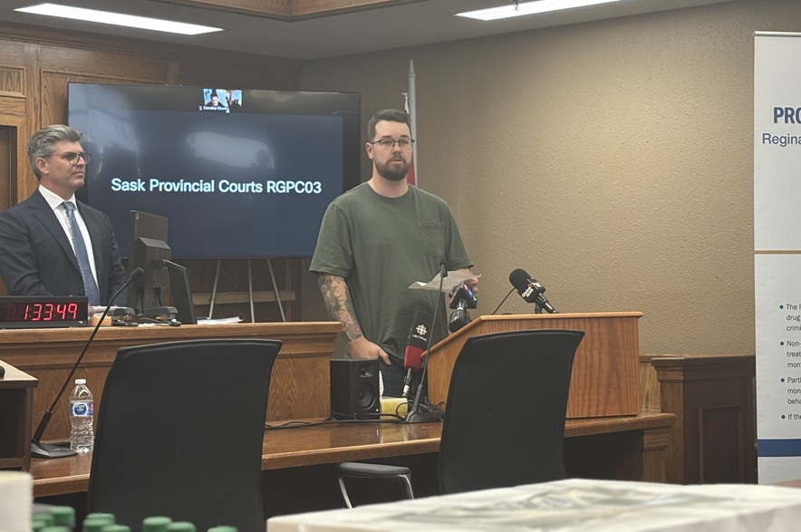 Ryan McCorriston speaks at a podium inside Regina Provincial Court during a Drug Treatment Court anniversary event.