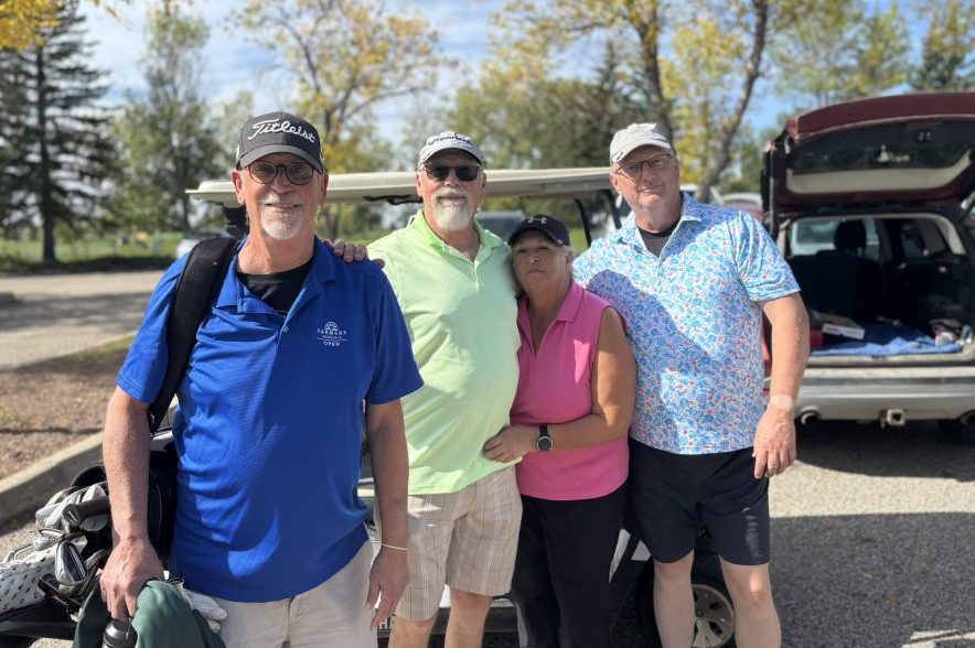 Ian Scarth and three other golfers standing together near a golf cart and golf clubs at Joanne Goulet Golf Course.