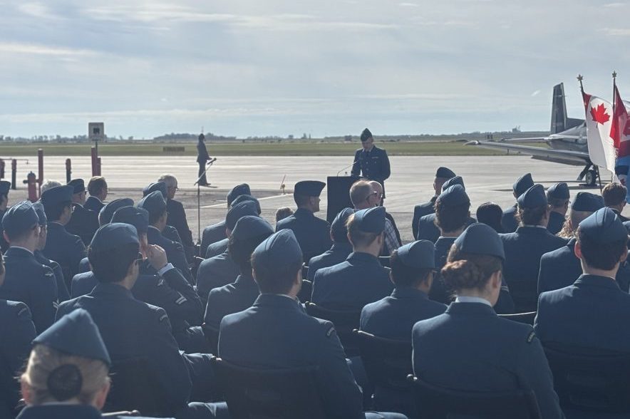 Royal Canadian Air Force members seated on the tarmac during the Battle of Britain commemoration at 15 Wing Moose Jaw.