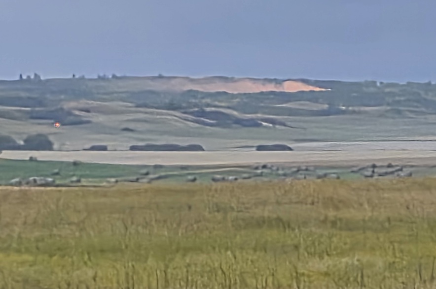 Orange smoke seen on the ground near a small plane crash site, near Kisbey, Sask., on Sept. 18, 2026.