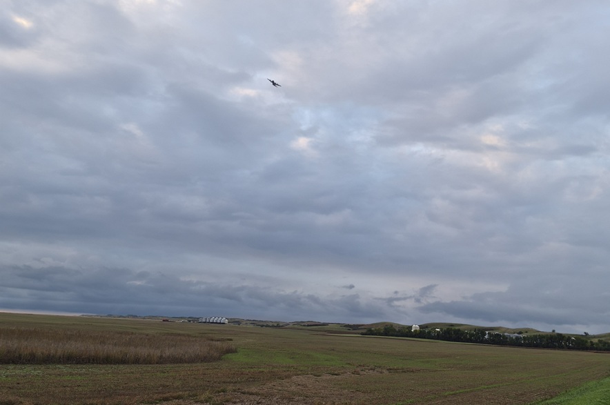 A plane, identified by a witness as a C130, searches over an area where a small plane crash occurred near Kisbey, Sask., on Sept. 18, 2026.