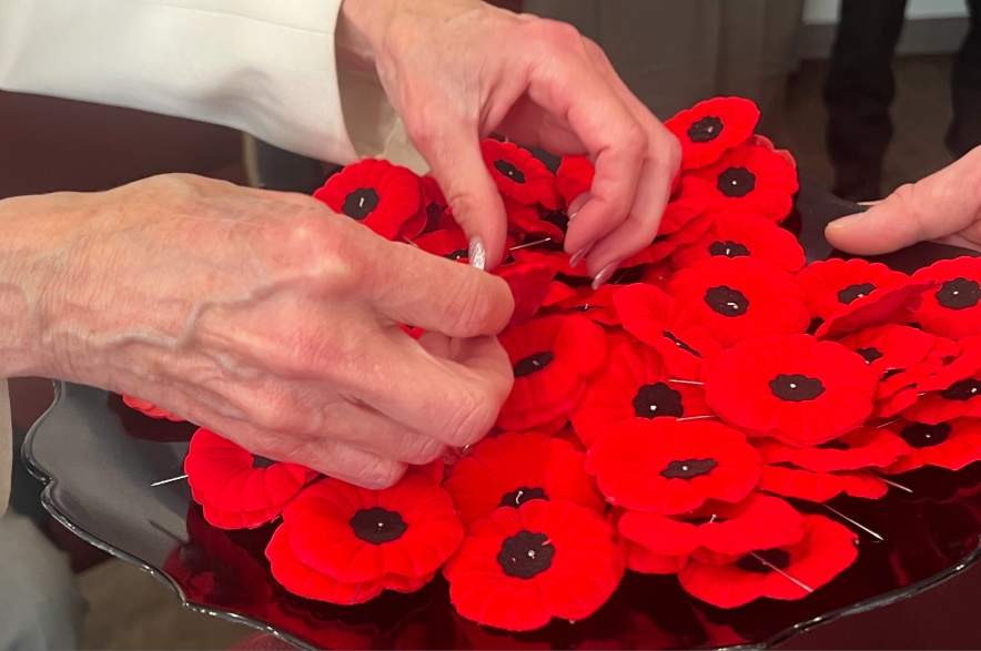 Lieutenant-Governor Bernadette McIntyre grabs poppies to pin on people at the Royal Canadian Legion Regina Branch on Thursday, October 22, 2026.