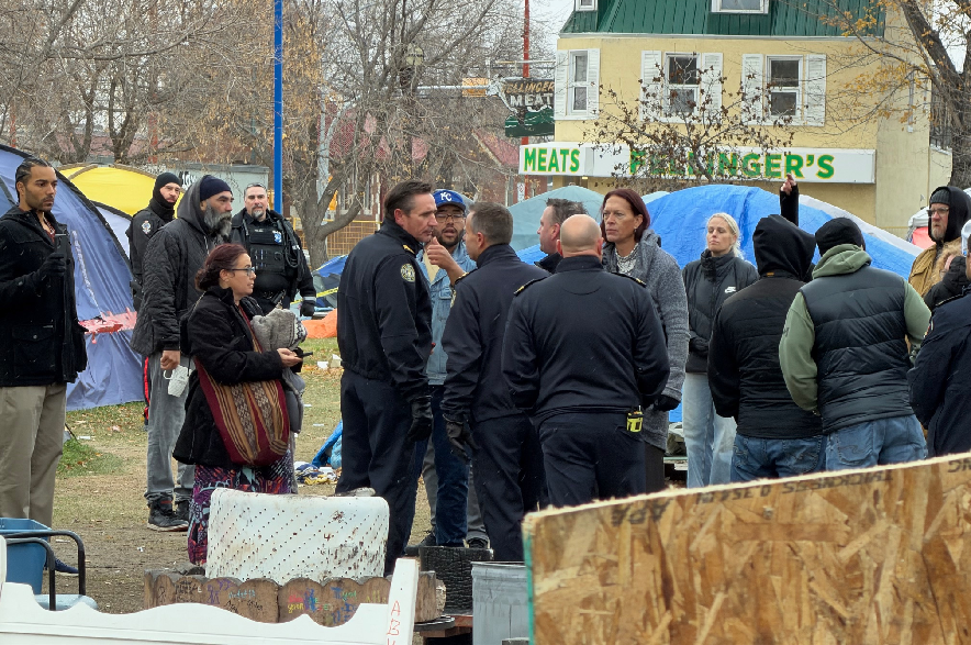 Police speak to residents of a homeless camp in Regina's Core Community Park as the camp is dismantled on Oct. 27, 2027.
