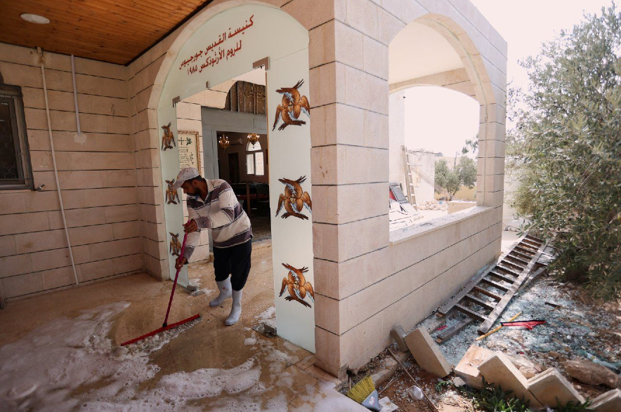 A worker scrubs the floor of St. George's Greek Orthodox Church in Jordan.