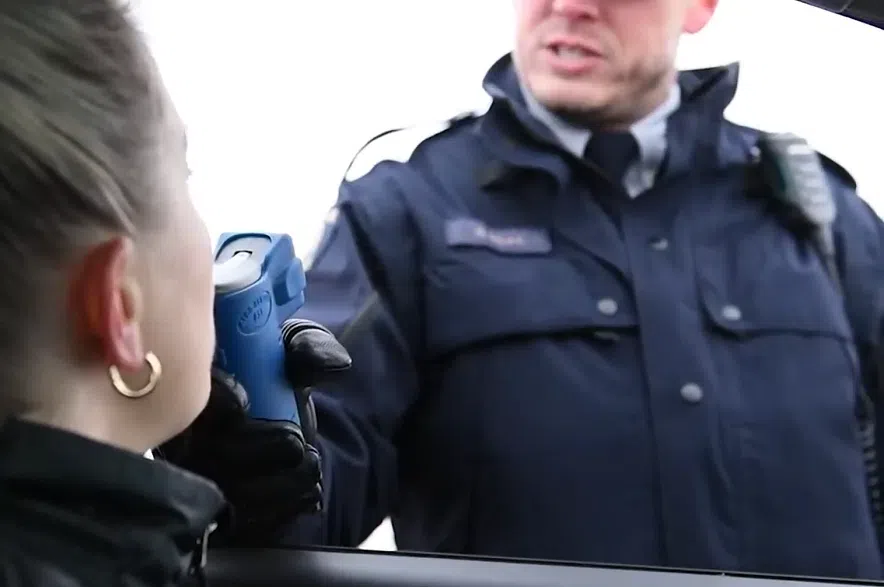 An RCMP officer administers a breath test.