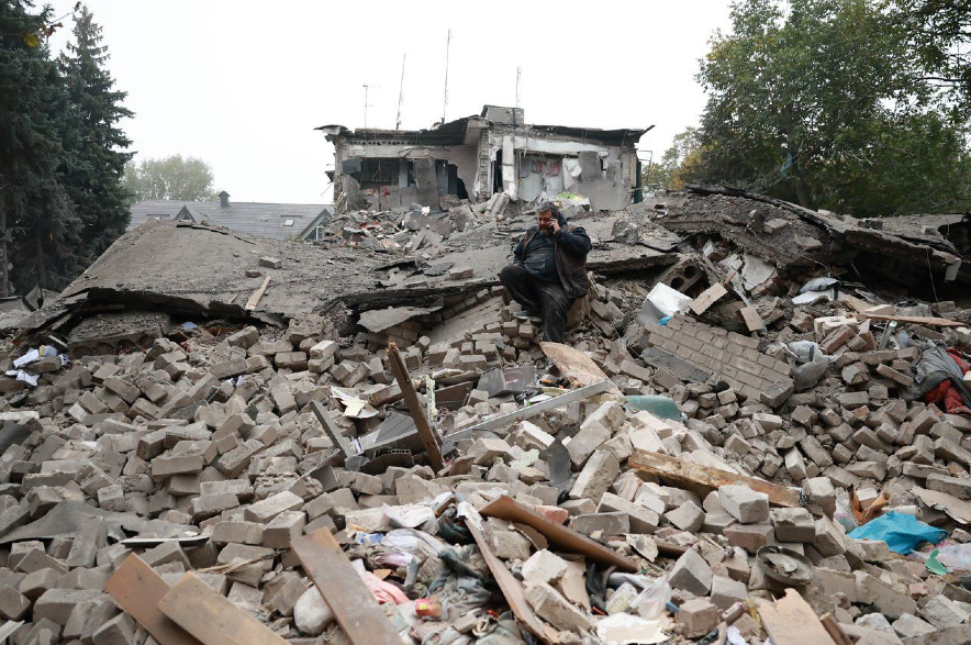 A man sitting on the rubble of a residential building destroyed by a Russian airstrike in Zaporizhzhia.