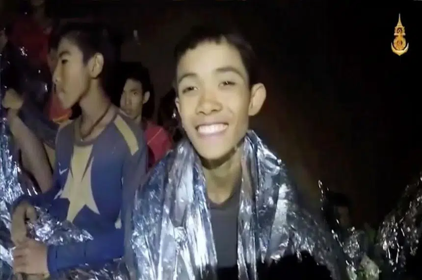 Warm in blankets, Thai boys smile, joke with rescuer in cave