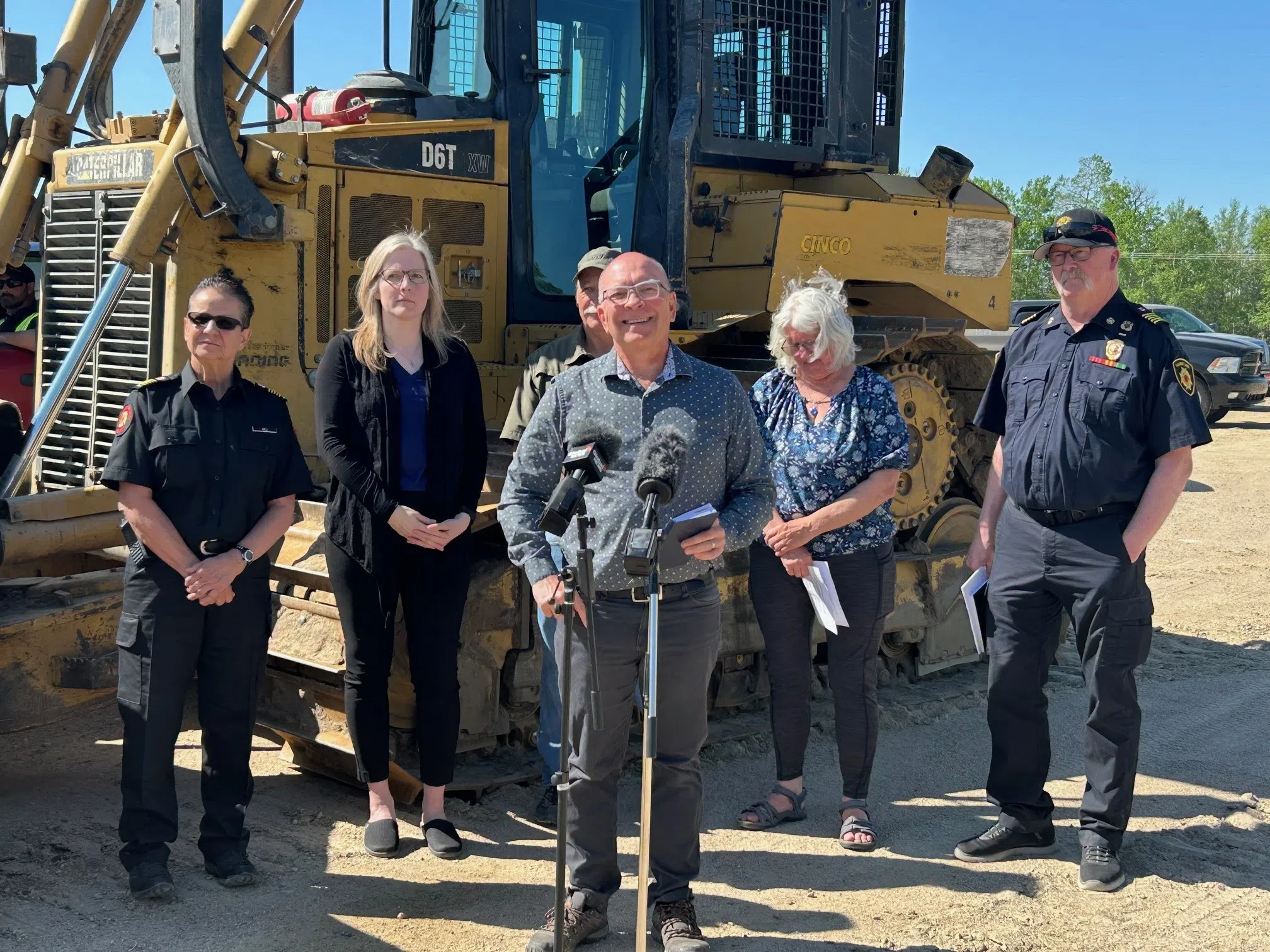 Brent Lutz, at the microphone, Chief Administrative Officer for the Resort Vilage of Candle Lake, speaking at a press conference held Tuesday morning with Fire Chief Jim Arnold, members of the Lakeland Fire Department, Candle Lake Mayor Colleen Lavoie and representatives from the RM of Paddockwood. (Nick Nielsen/paNOW Staff)