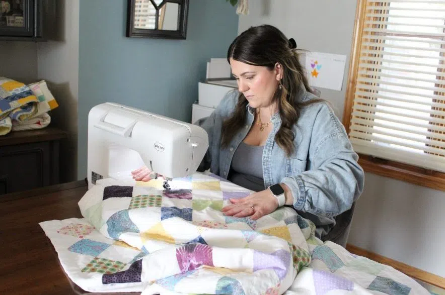Ashleigh Hemsley sits at her sewing machine